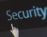 Nahaufnahme eines Computerbildschirms mit dem Wort 'Security' und einer klickenden Mauszeiger-Hand – Symbol für Cybersicherheit und Datenschutz.